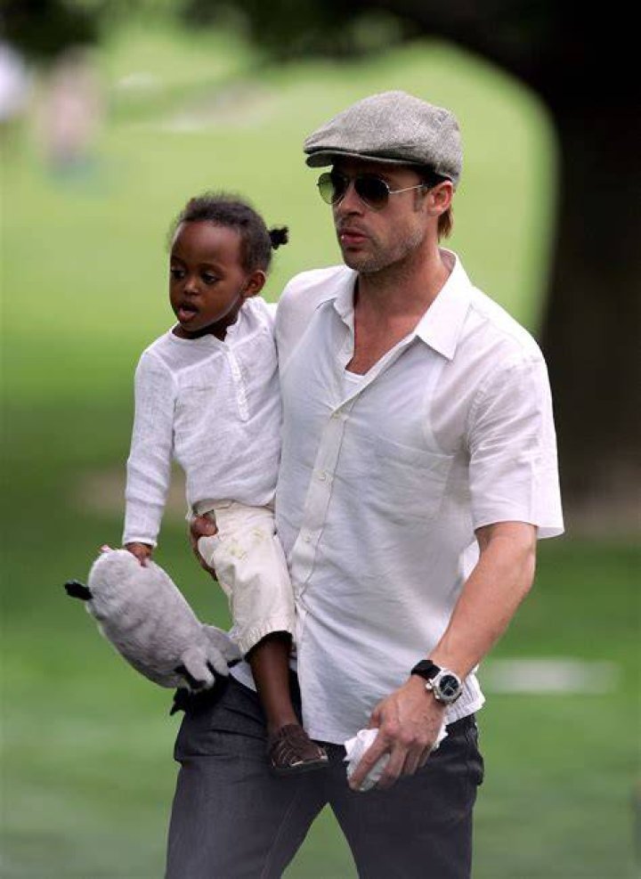 Brad Pitt carries his daughter Vivienne as he climbs aboard a motor boat in Venice, Italy